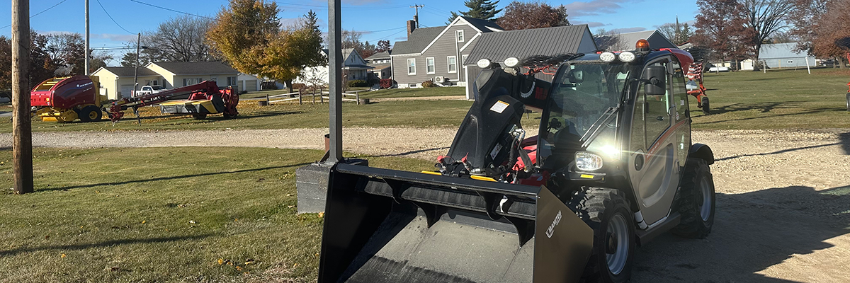 skid steer in front of sign