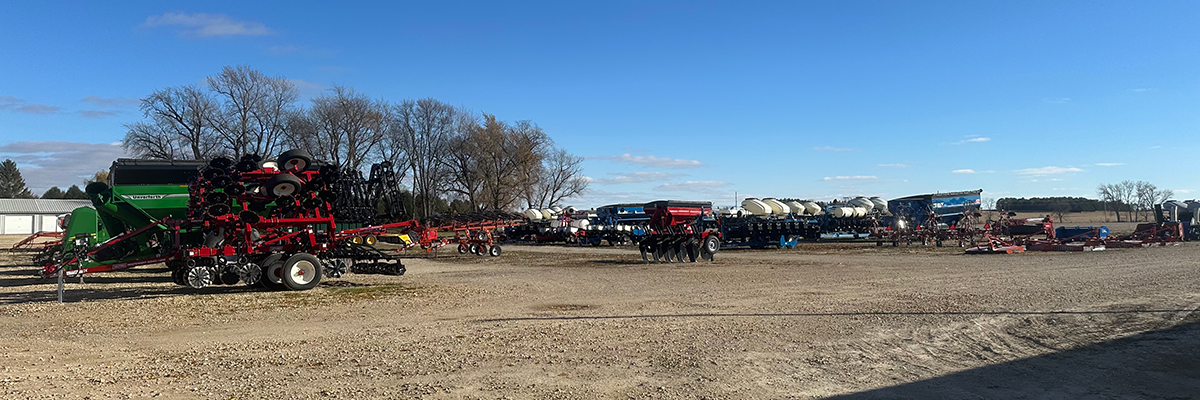 Wide image of parked Farm Equipment on gravel road